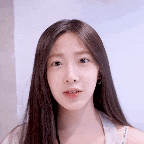 a woman with long hair is wearing a white tank top that says bellinda on it