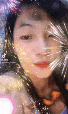 a woman 's face is surrounded by fireworks and says tiktok