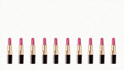 a row of pink lipsticks lined up in a row on a white background