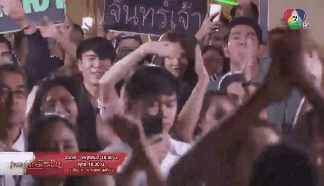 a crowd of people are standing in front of a sign that says ' จันทร์ เจ้า '