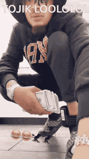 a man is kneeling down holding a stack of money and the words tojik loololol are above him