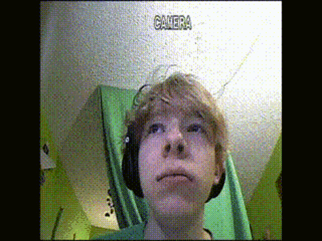 a young boy wearing headphones is looking up at a camera