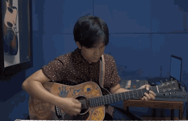 a man playing an acoustic guitar with a sticker on it that says taylor