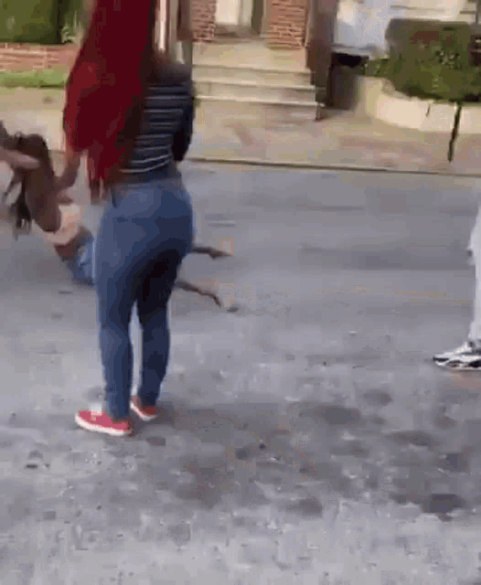 a group of people are standing on a sidewalk with a dog .