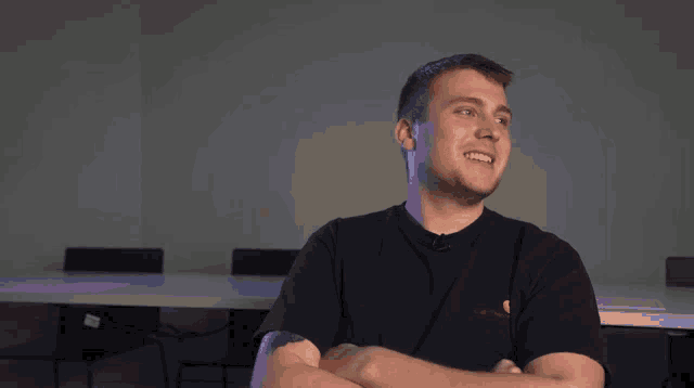 a man wearing a black carhartt shirt is smiling