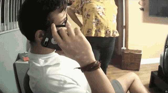 a man wearing sunglasses is talking on a cell phone with a sticker on it that says ' a '