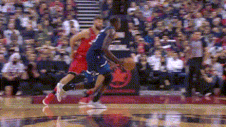 a basketball game is being played in front of a crowd .