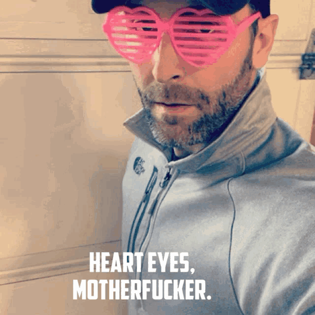 a man wearing heart shaped sunglasses with the words heart eyes motherfucker on the bottom
