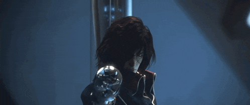 a woman with dark hair is holding a sphere in her hand