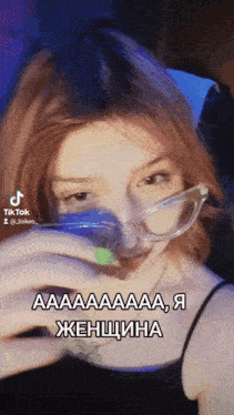 a woman wearing glasses and a black tank top has a tiktok sticker on her face