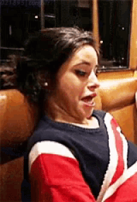 a woman is making a funny face while sitting in a diner booth .
