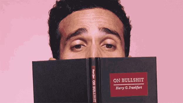 a man covering his face with a book called on bullshit