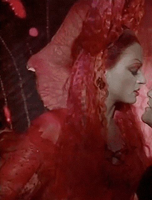 a woman with red hair is kissing a man