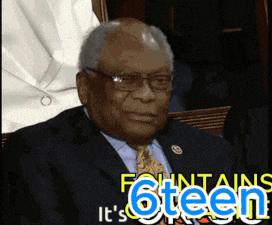 a man in a suit and tie sitting in front of a sign that says fountains 6teen