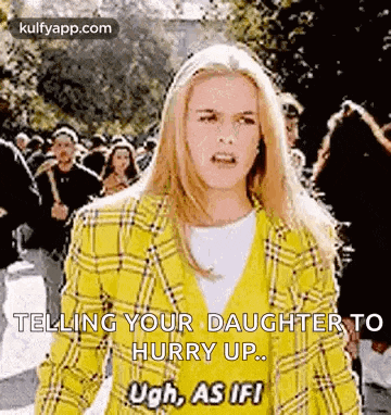 a woman in a yellow plaid jacket is standing in front of a crowd of people and telling her daughter to hurry up .