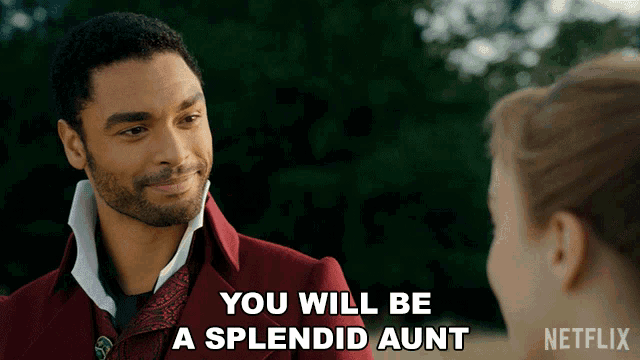 a man in a red suit says " you will be a splendid aunt " in front of a woman