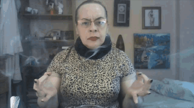 a woman wearing glasses and a leopard print shirt is making a face