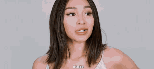 a woman wearing a white tank top with maddie written on it