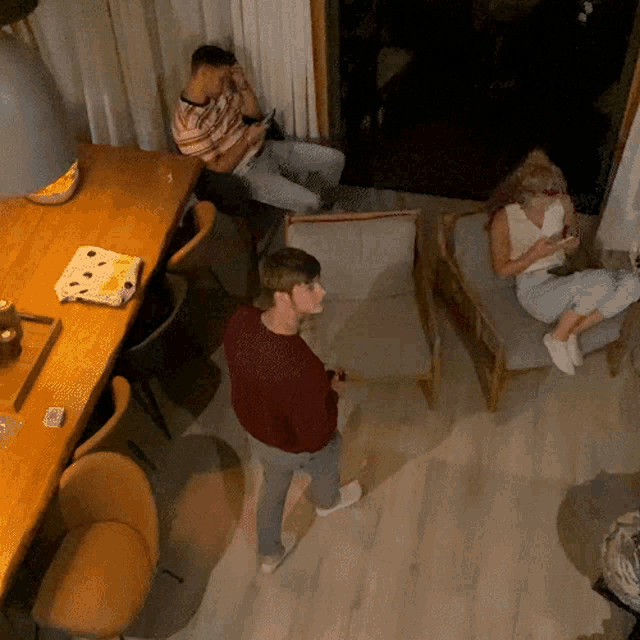 a man in a red sweater stands in the middle of a room