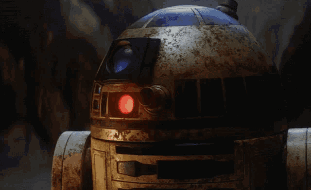 a close up of a star wars robot with a red light