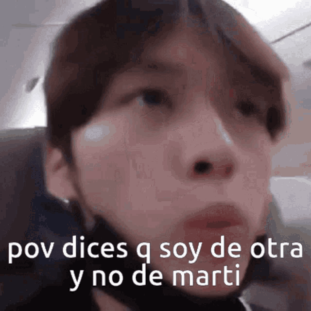a close up of a person 's face with the words pov dices q soy de otra y no de marti written above it .