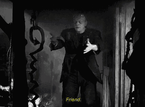 a black and white photo of frankenstein holding a snake with the words friend below him