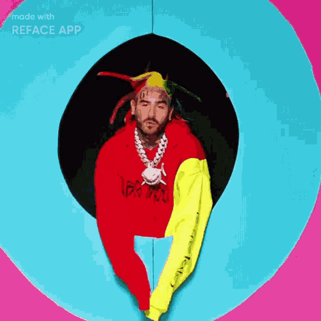 a man with dreadlocks and a beard is wearing a red hoodie and a yellow jacket