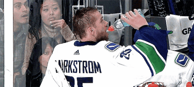 a hockey player named nyrkstrom is drinking from a bottle