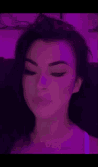 a woman is making a funny face in front of a purple background and the word disgusting is on the bottom .
