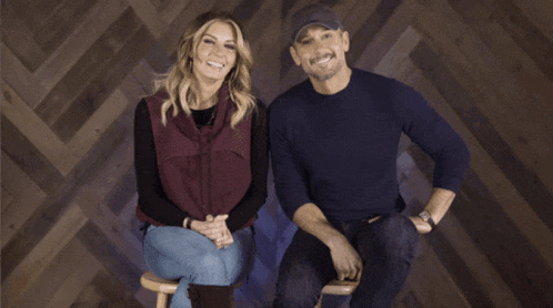 a man and a woman are sitting next to each other on a stool