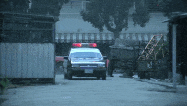 a black police car with a license plate that says yk 8305 drives down a street