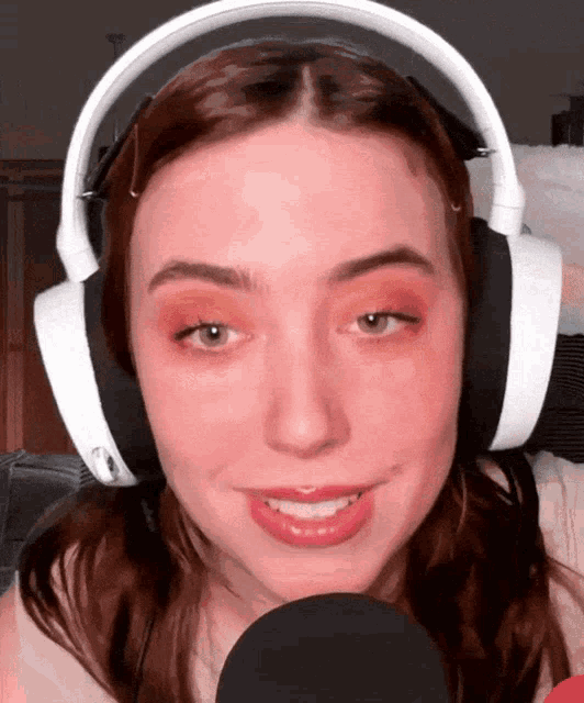 a woman wearing headphones and a microphone is smiling