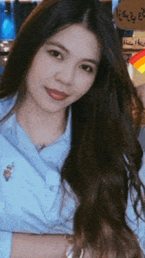 a woman wearing a blue shirt with a polo emblem on the collar