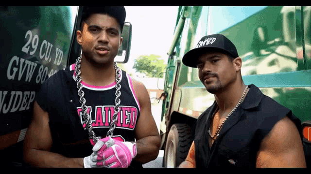 two men standing in front of a truck that says 29 cu yd gvw 80