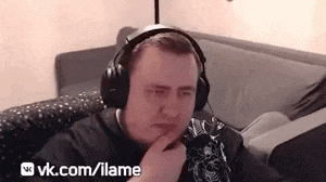 a man wearing headphones is sitting on a couch and looking at the camera .