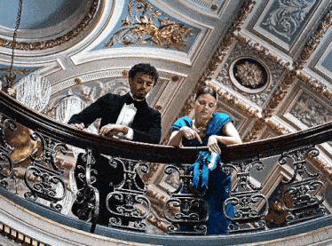 a man and a woman are standing on a balcony
