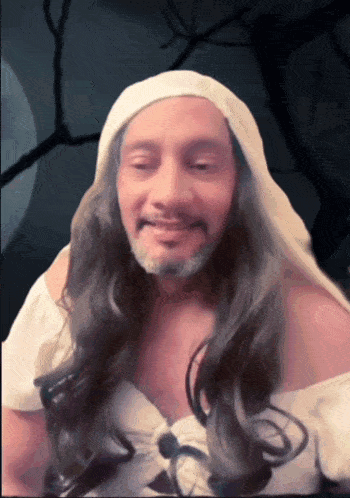 a man with long hair and a beard wears a white robe