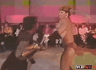 a couple of people dancing in a room with a sign that says vcrparty on it