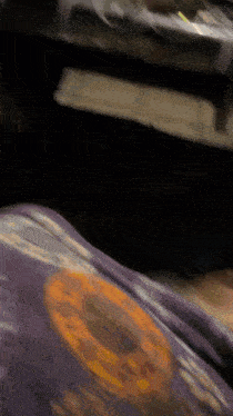 a blurry picture of a person 's feet with a purple shirt on