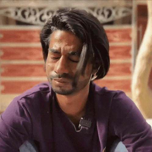 a man wearing a purple shirt with a tag that says ' emporio armani ' on it
