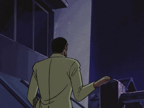 a man in a yellow suit is standing in front of a building at night