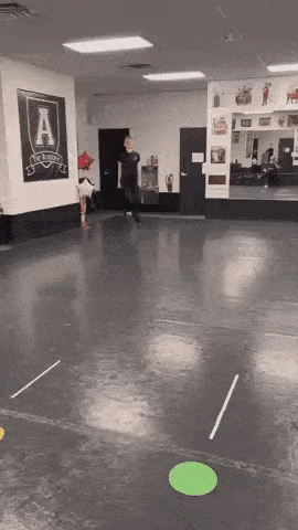 a man is dancing in a dance studio with a sign on the wall that says a .