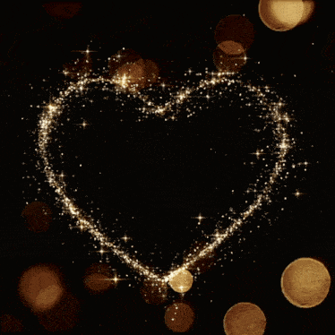 two wedding rings are surrounded by sparkles in the shape of a heart on a black background