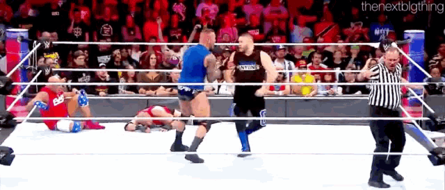 a wrestling match is going on in front of a crowd and the next big thing is written on the bottom