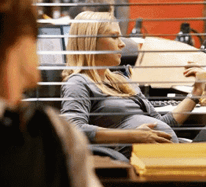 a pregnant woman is sitting at a desk in front of a computer