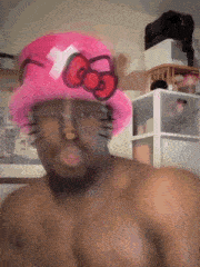 a shirtless man wearing a hello kitty hat