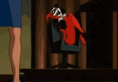 harley quinn is laying on her back in a chair while a woman stands next to her .