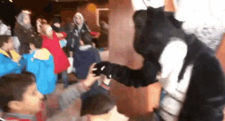 a group of children are playing with a black and white animal costume
