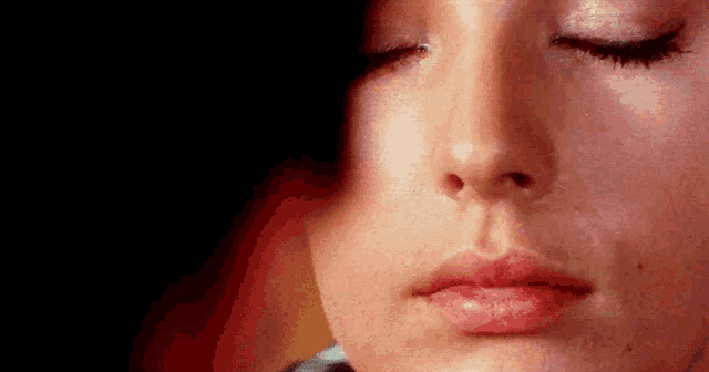 a close up of a woman 's face with closed eyes