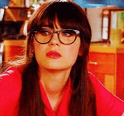the woman is wearing glasses and a red shirt .